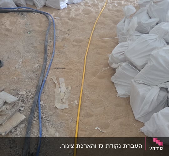 שקי חול וצינורות באתר בנייה